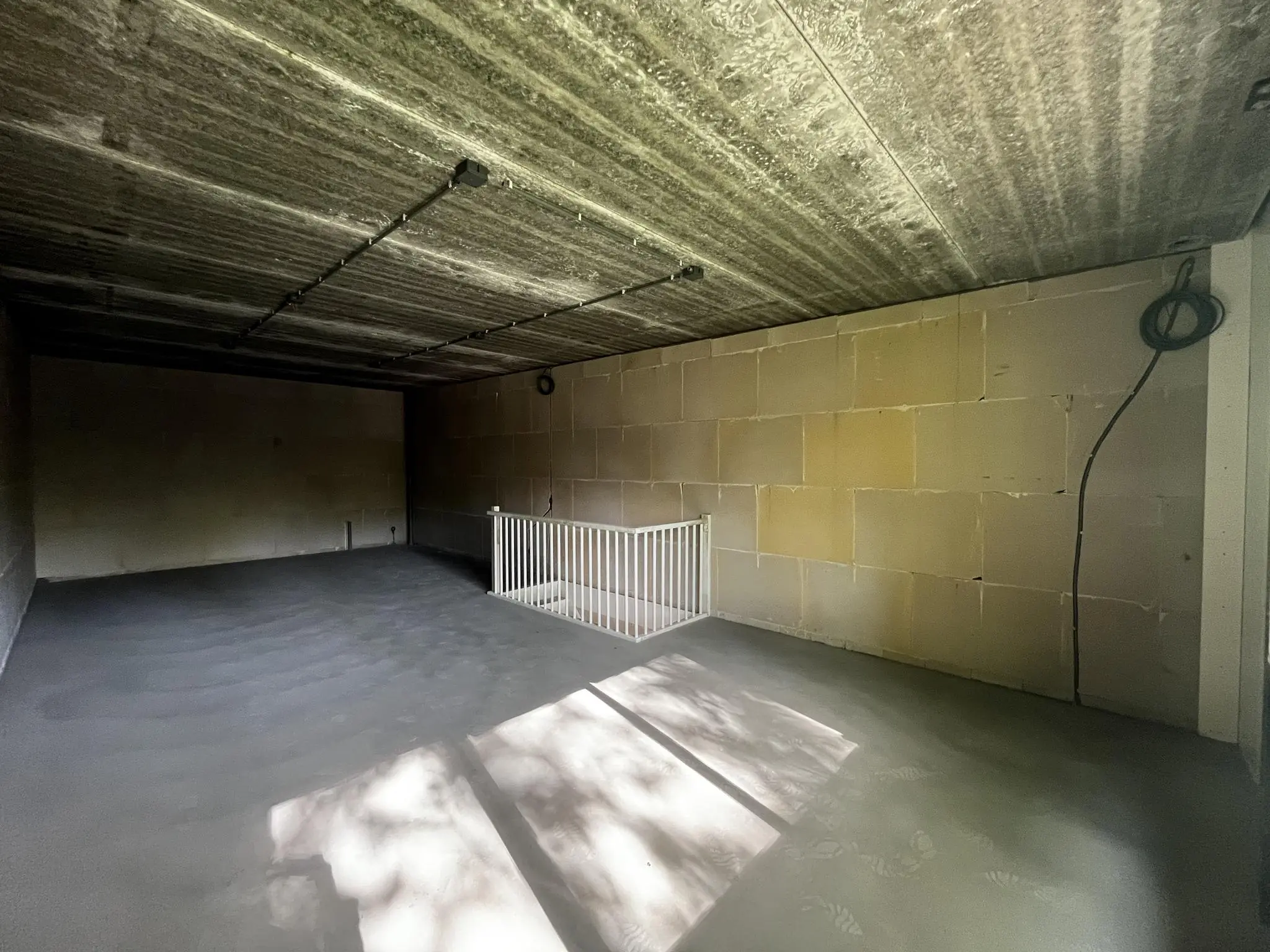 Leeg betonnen souterrain met onafgewerkte muren en een trapopening met wit hekwerk aan de Broekdijk West.